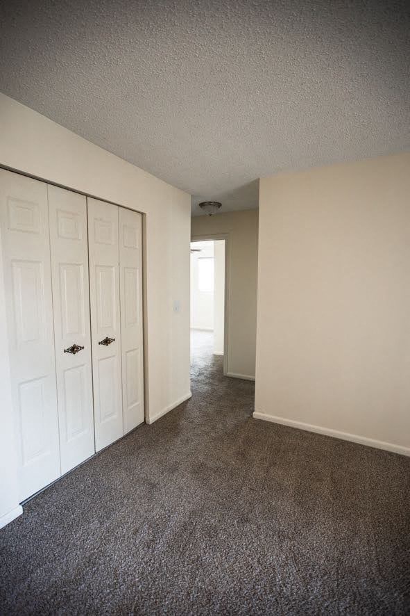 A room with a carpeted floor and a white door.