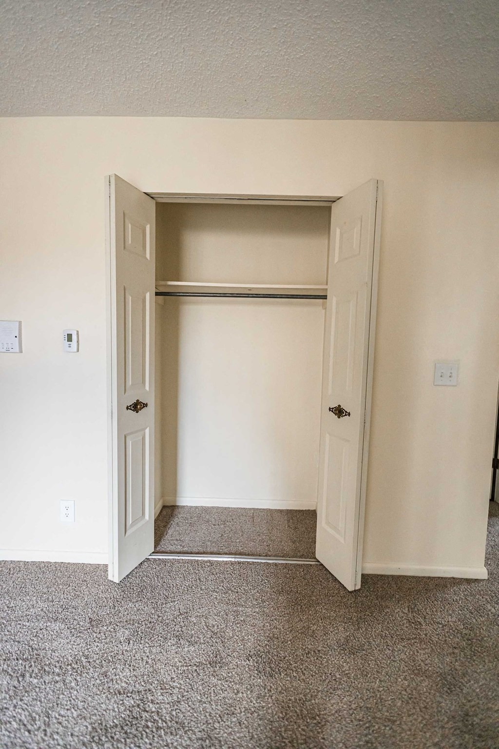 A room with a carpeted floor and a white door.
