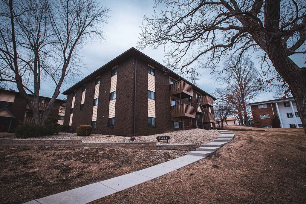 A brown building with a white walkway in front of it.