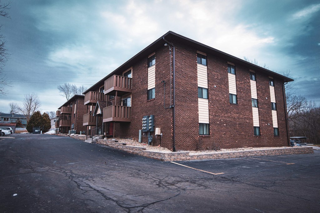 A large brick building with a parking lot in front.