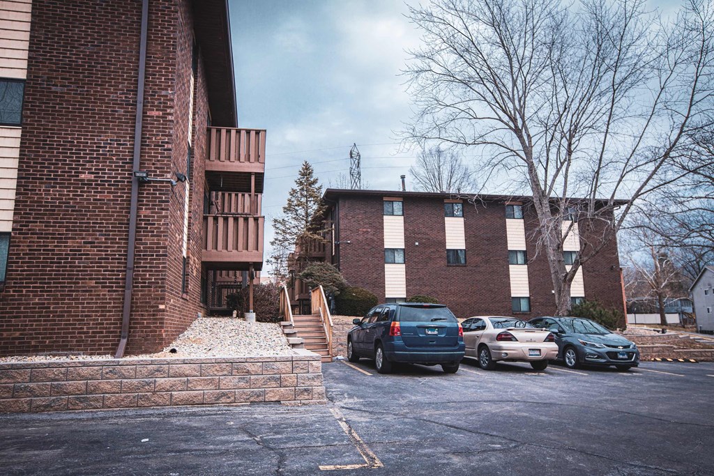 A parking lot with cars and a building in the background.
