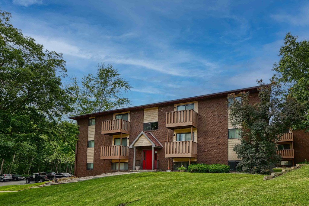 A large apartment building with a red door in the front.