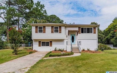 a white house with a blue door and a sidewalk