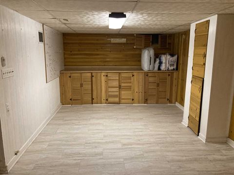 an empty basement with wooden cabinets and a white floor