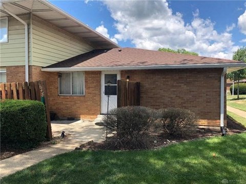 a brick house with a sidewalk in front of it