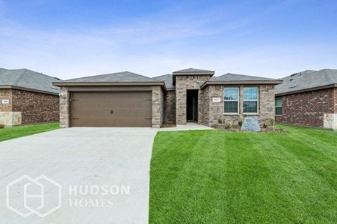 a brick house with a garage and a lawn