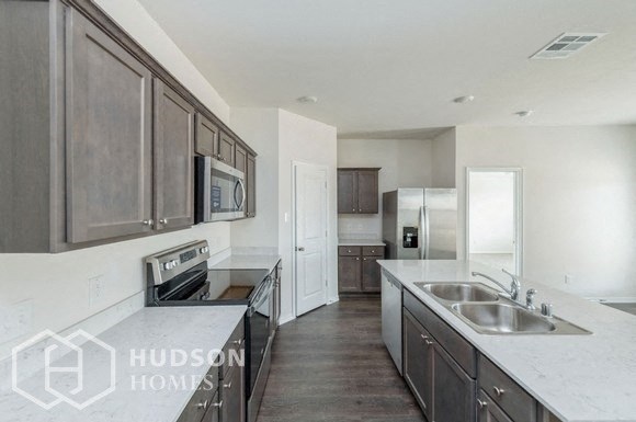 a large kitchen with stainless steel appliances and marble counter tops
