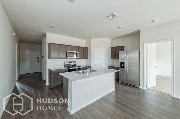 a white kitchen with a large island and stainless steel appliances