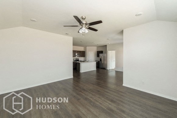 an empty living room with white walls and a ceiling fan