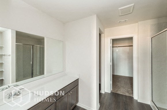 a white bathroom with a large mirror and a closet