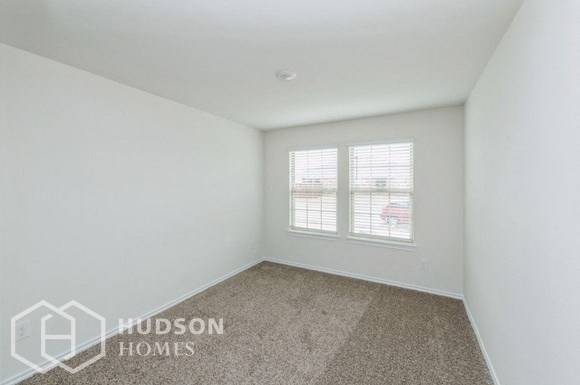 a bedroom with white walls and a window