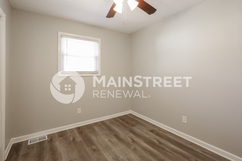 a white room with a window and a ceiling fan