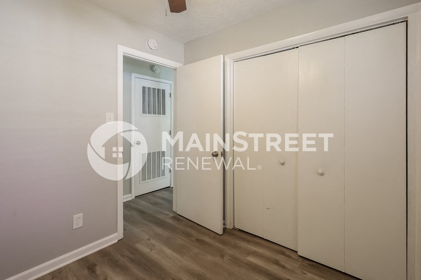 a bedroom with white closets and a door to a hallway