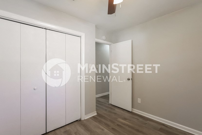 renovated apartment in a building with wood floors and white closets