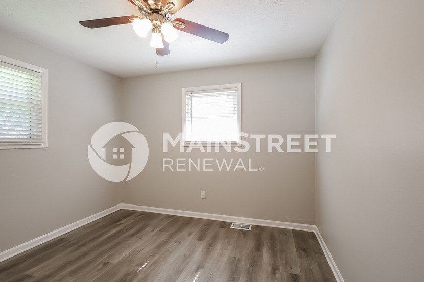 an empty room with a ceiling fan and a window