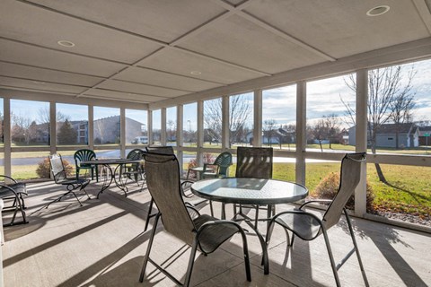 a patio with chairs and tables on a porch