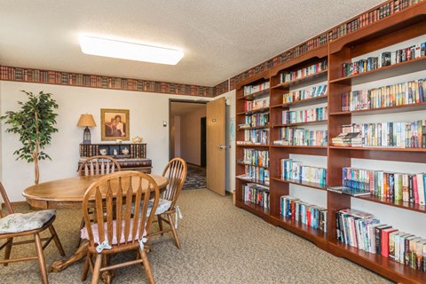 a library with a table and chairs and shelves of books
