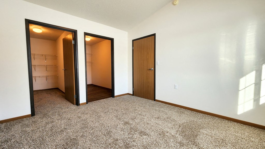 a empty room with two doors and a closet