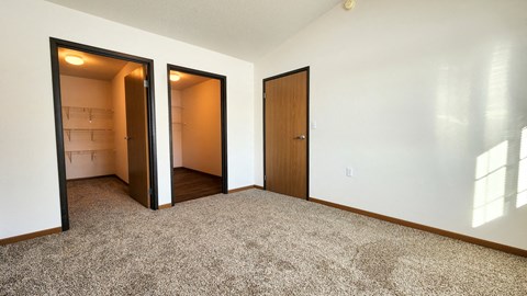a empty room with two doors and a closet