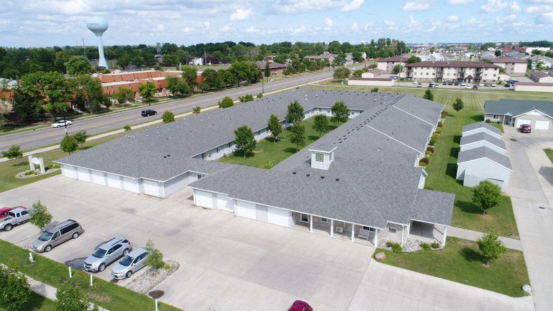 an aerial view of a building with a roof and a parking lot
