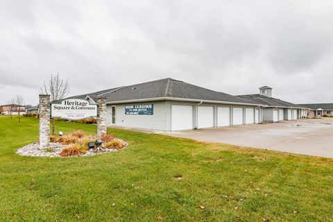 the front of a building with a sign in the grass