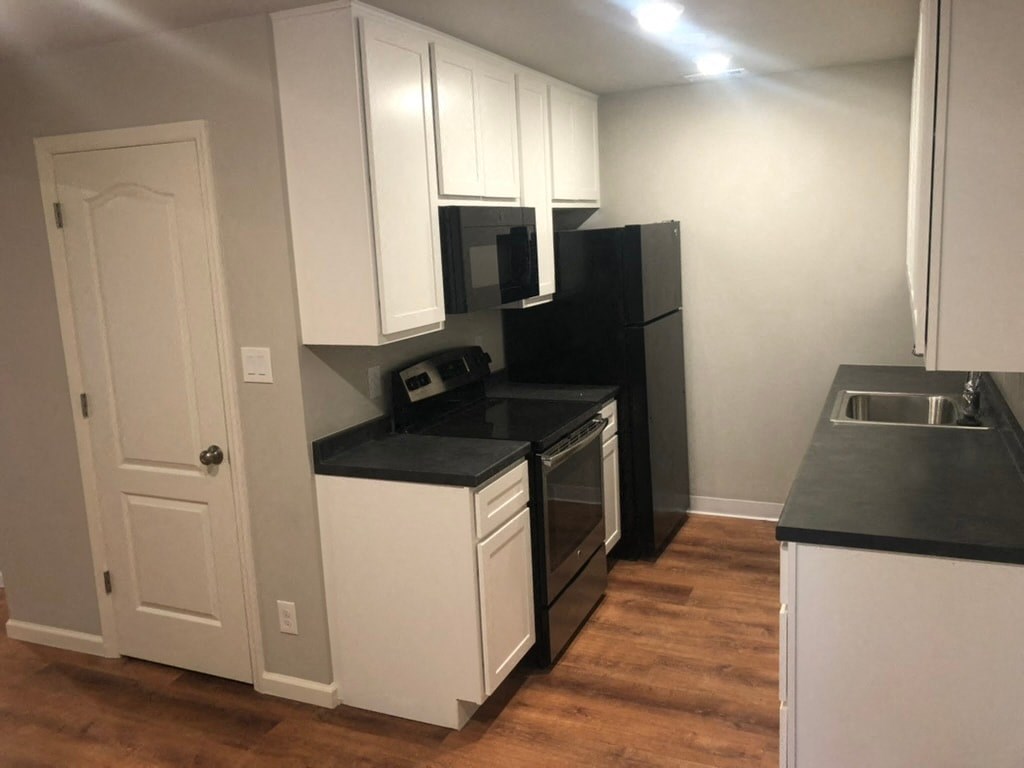 a kitchen with white cabinets and a stove and a refrigerator