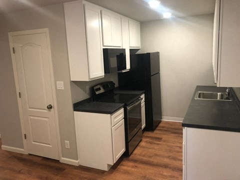 a kitchen with white cabinets and a stove and a refrigerator