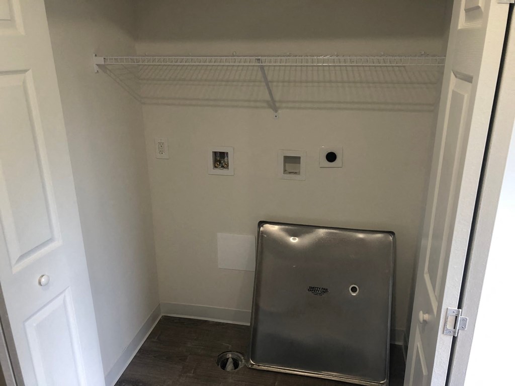 a stainless steel urinal in the corner of a room