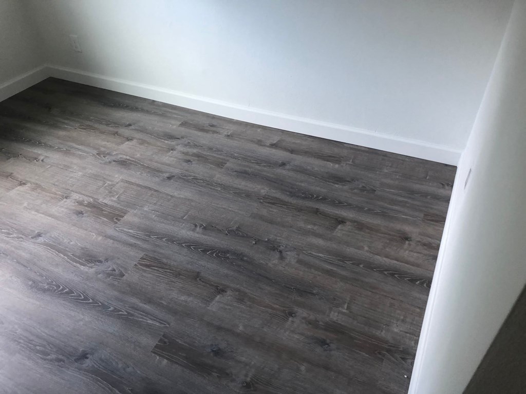 a room with hardwood flooring and a white wall