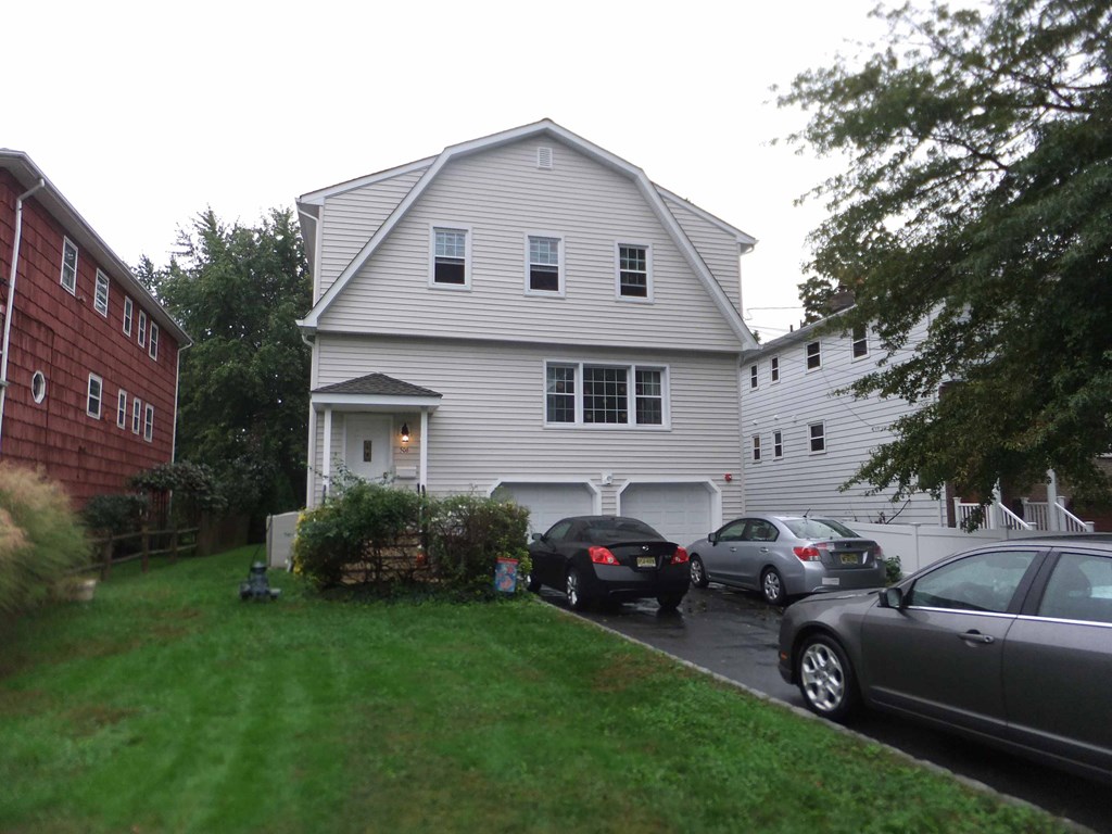 a white house with cars parked in a parking lot