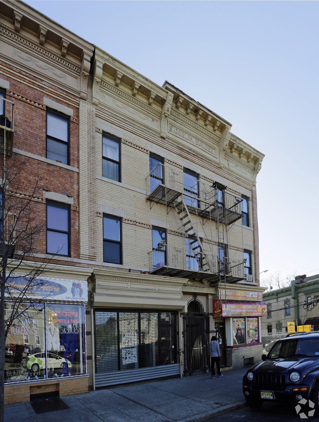 a brick building with a fire escape on a city street