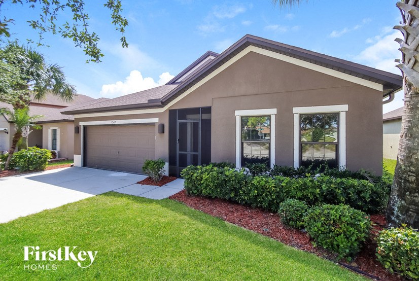 A house with a brown roof and a garage door is for sale.