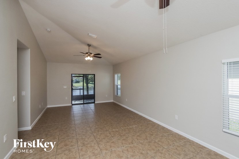 A spacious room with a ceiling fan and sliding glass doors.
