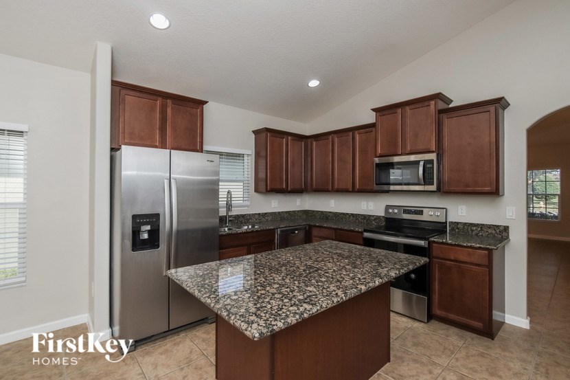 A kitchen with granite countertops and stainless steel appliances.