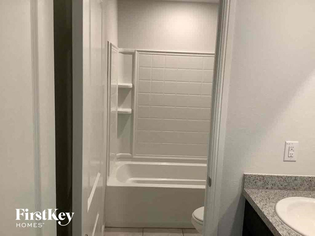 a bathroom with a shower and a sink and a toilet