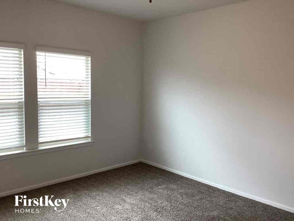 an empty room with two windows in it