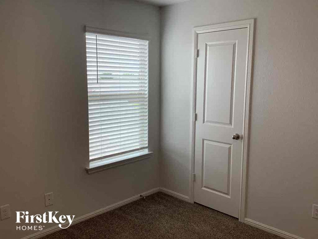 a small room with a window and a white door