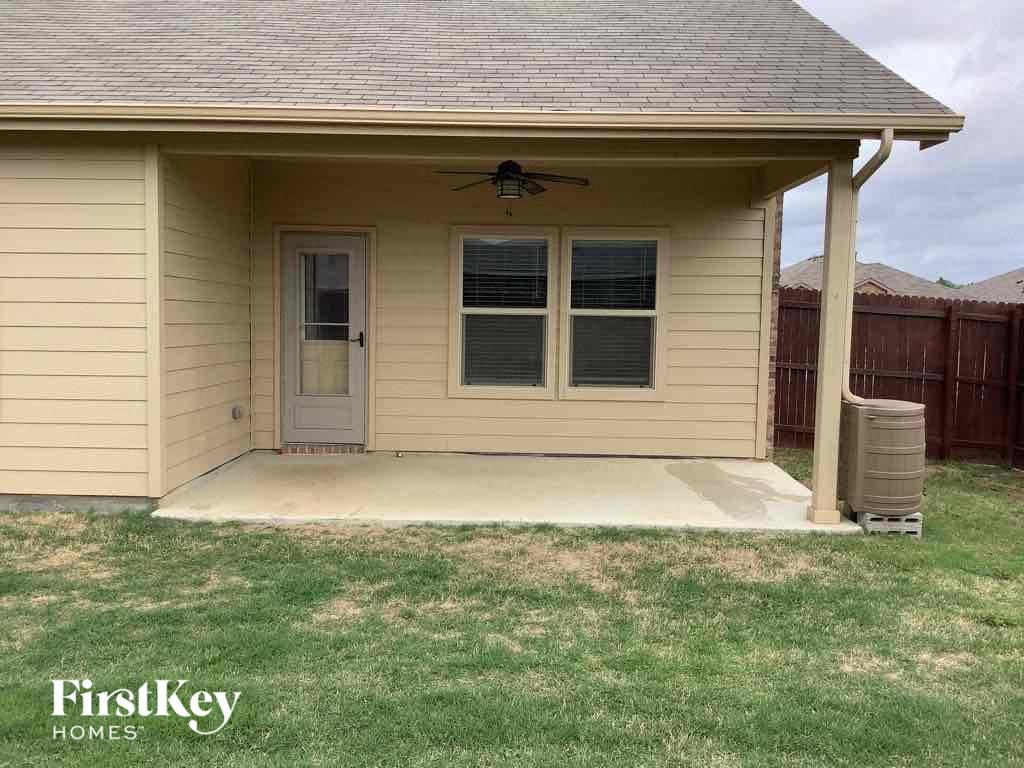 the front of a house with a porch and a fan