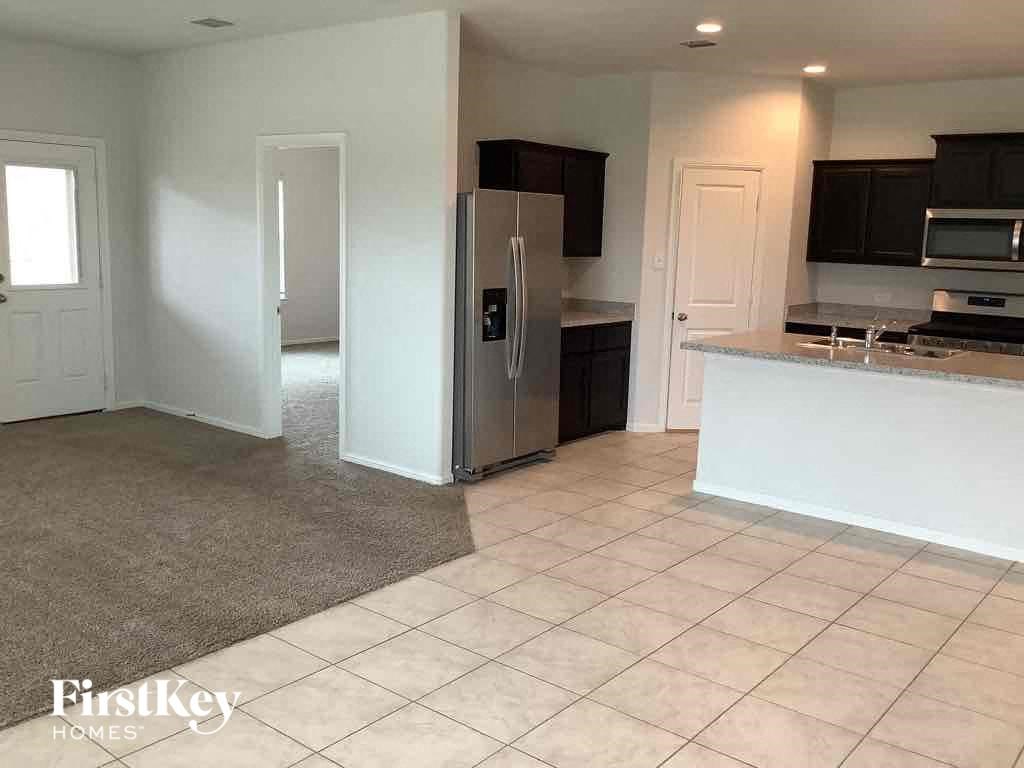 an empty kitchen with a stainless steel refrigerator