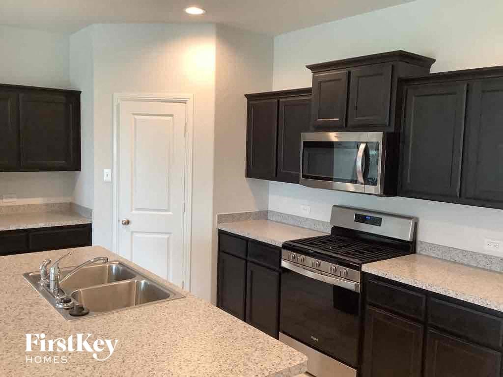 an empty kitchen with black cabinets and a sink