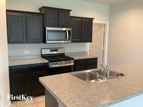 a kitchen with granite counter tops and black cabinets