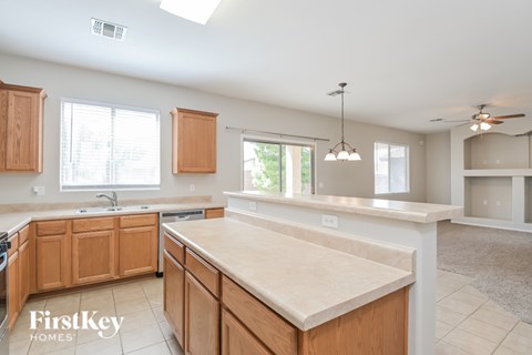 A kitchen with wooden cabinets and a marble countertop.