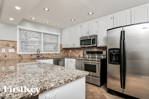 A kitchen with granite countertops and stainless steel appliances.