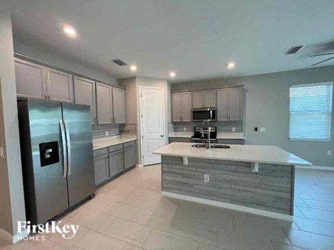 a large kitchen with a stainless steel refrigerator