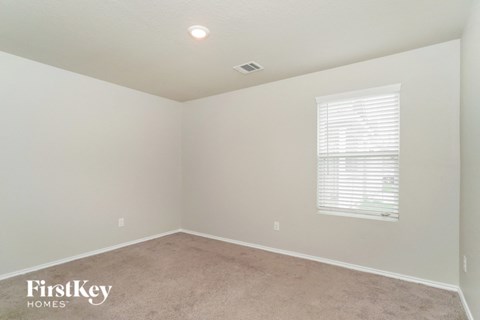a bedroom with a carpeted floor and a window