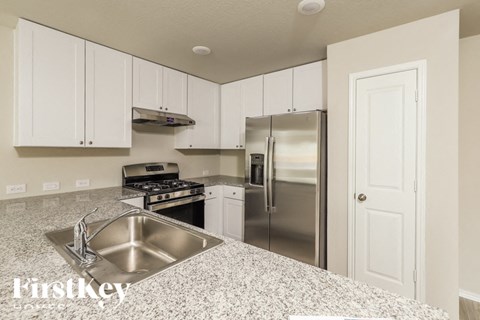 A kitchen with a stainless steel sink and refrigerator.