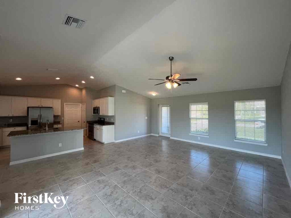 A spacious room with a fan and tiled flooring.