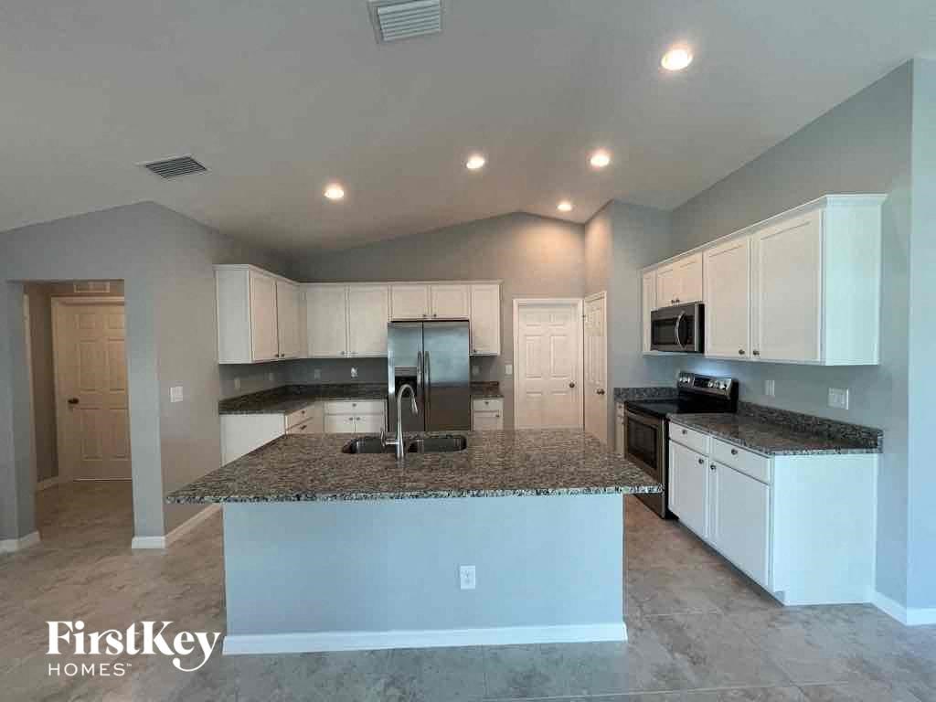 A kitchen with granite countertops and white cabinets.