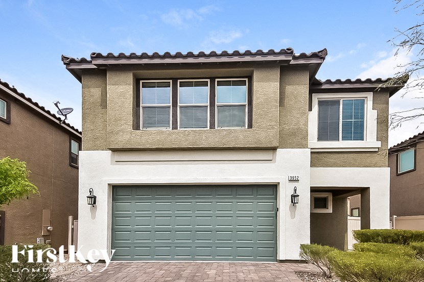 A two-story house with a garage door and a driveway.