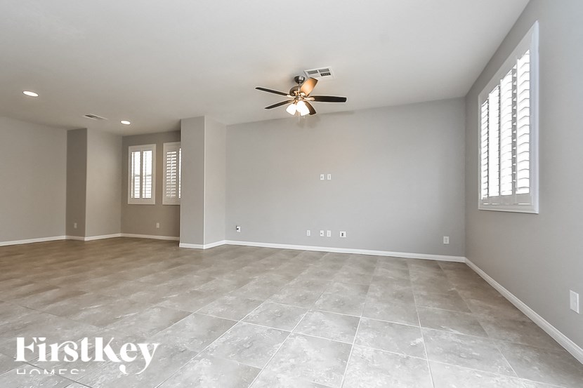 A spacious room with a ceiling fan and tile flooring.